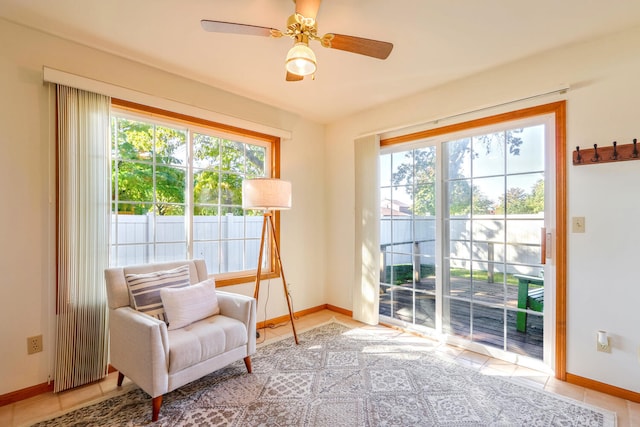 living area with light tile patterned floors and ceiling fan