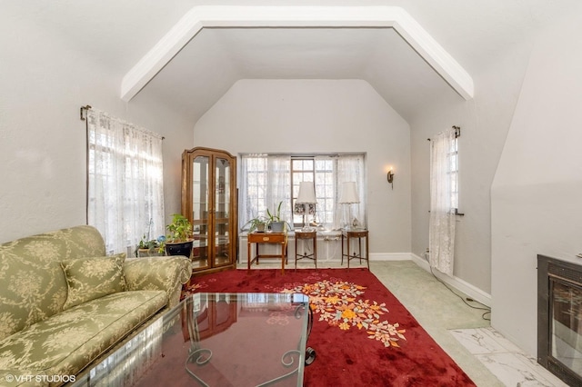 living room with a tile fireplace, lofted ceiling, and a wealth of natural light