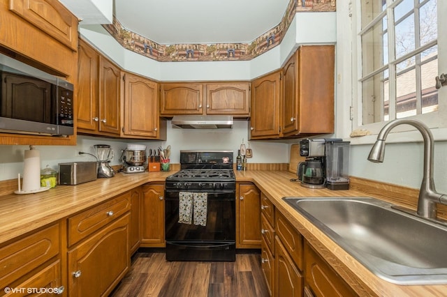 kitchen featuring sink, black range with gas stovetop, and dark hardwood / wood-style floors