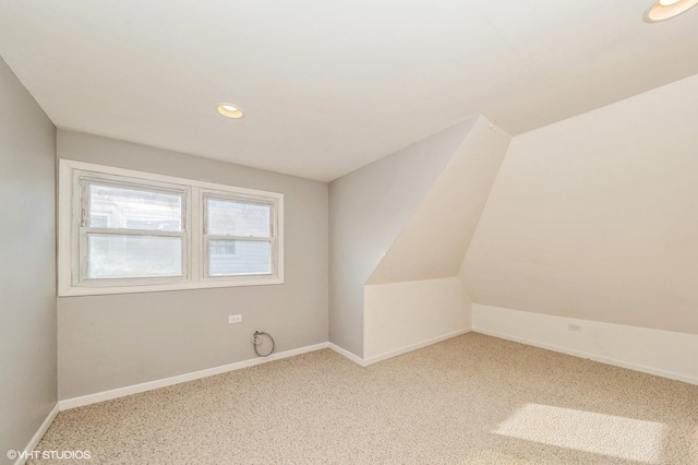 additional living space featuring carpet and lofted ceiling