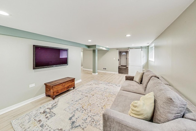 living room with a barn door and hardwood / wood-style floors