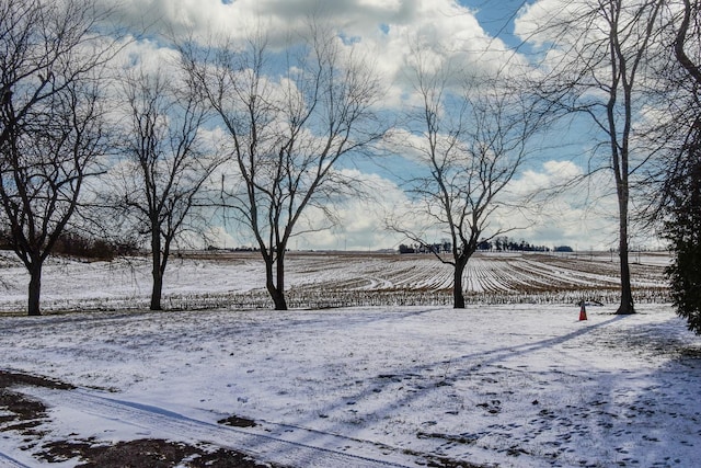 yard layered in snow featuring a rural view