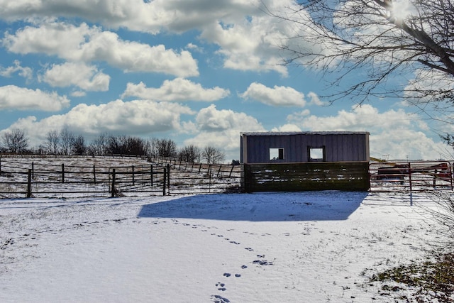 yard covered in snow with a rural view