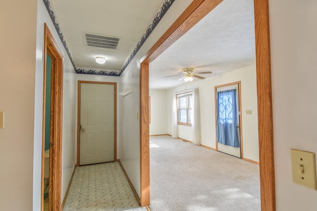 hallway featuring light colored carpet