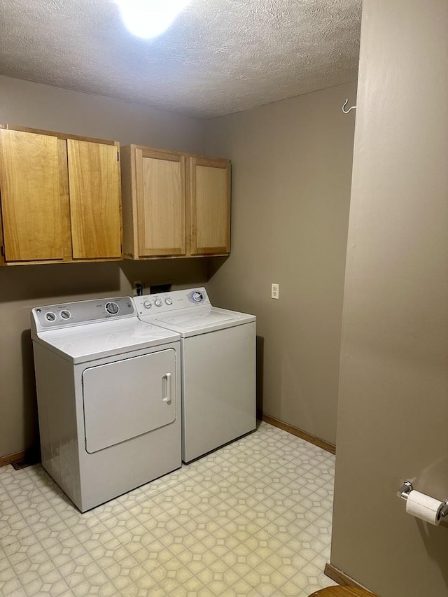 laundry room with cabinets, separate washer and dryer, and a textured ceiling