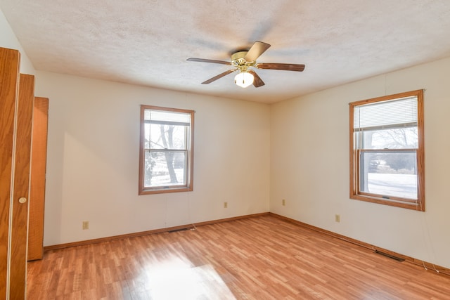 spare room featuring ceiling fan, a textured ceiling, and light wood-type flooring