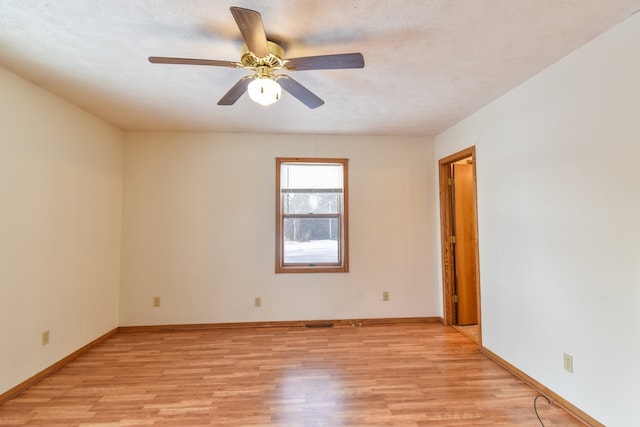 empty room with ceiling fan, light hardwood / wood-style flooring, and a textured ceiling