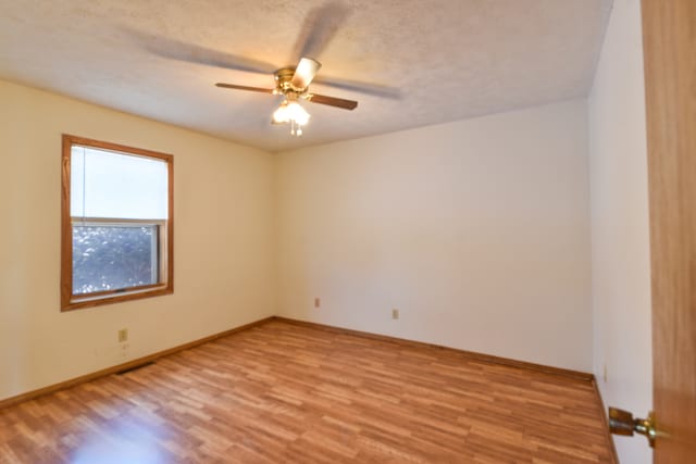 spare room with ceiling fan, light hardwood / wood-style flooring, and a textured ceiling