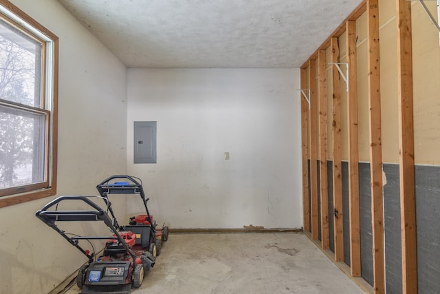 miscellaneous room featuring a wealth of natural light, electric panel, and concrete floors