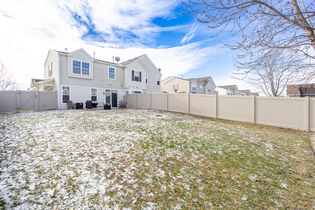 view of snow covered back of property