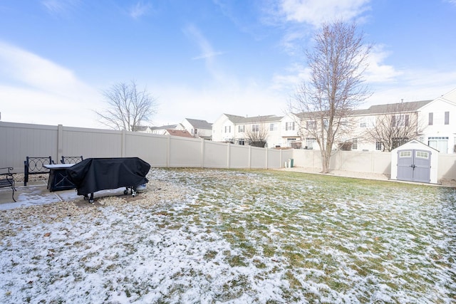 snowy yard featuring a storage shed