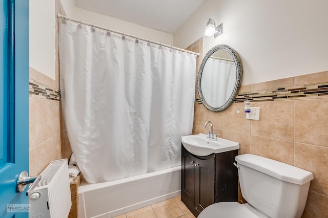 full bathroom featuring radiator heating unit, toilet, tile walls, and shower / bath combination with curtain