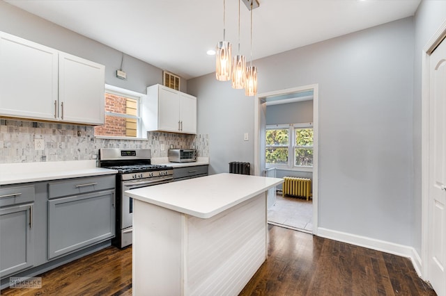 kitchen with stainless steel gas range oven, radiator, gray cabinets, tasteful backsplash, and white cabinetry