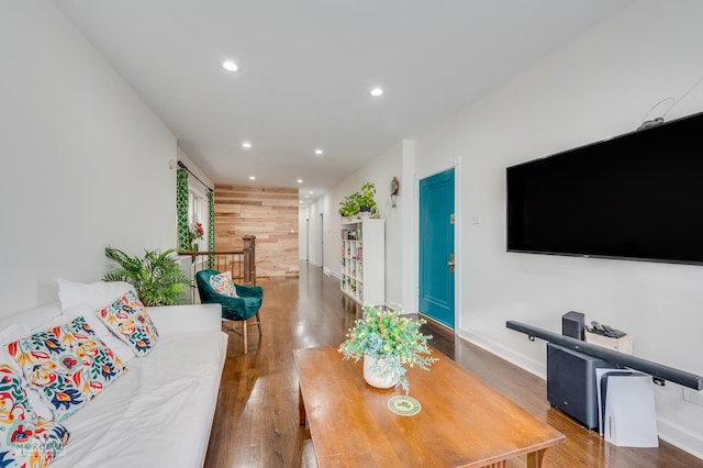 living room with wooden walls and dark wood-type flooring