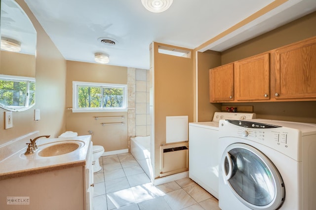 laundry room with light tile patterned floors, washing machine and dryer, and sink