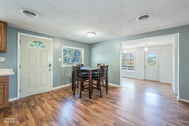 dining space with a textured ceiling and dark hardwood / wood-style floors