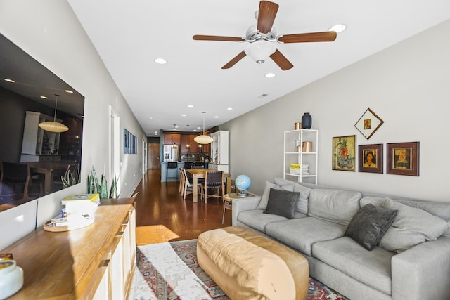 living room with ceiling fan and dark hardwood / wood-style flooring