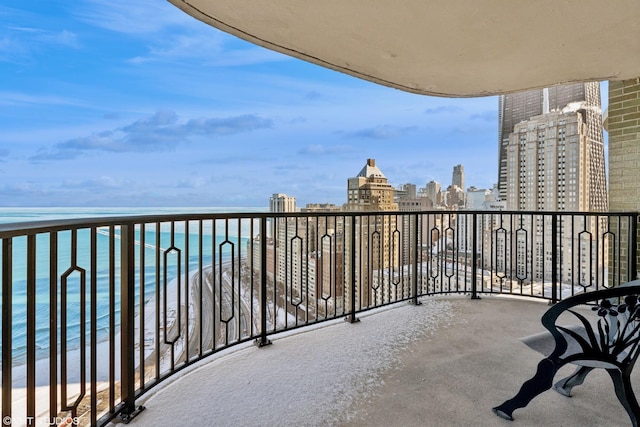 balcony featuring a view of the beach and a water view