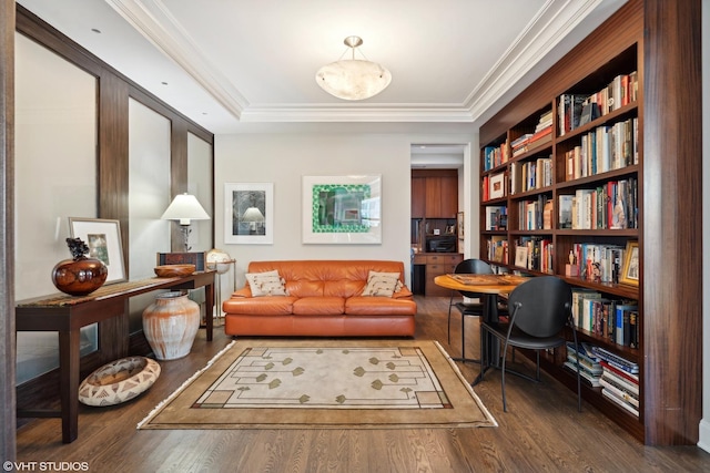 living area with hardwood / wood-style floors, built in shelves, and crown molding