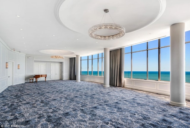 unfurnished living room with a raised ceiling and a water view