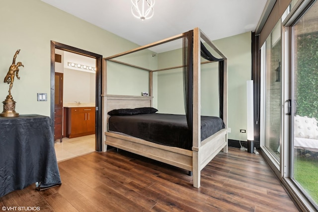 bedroom featuring sink, ensuite bath, dark wood-type flooring, and access to outside