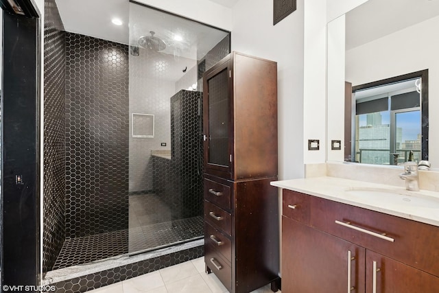 bathroom featuring vanity, tile patterned floors, and tiled shower