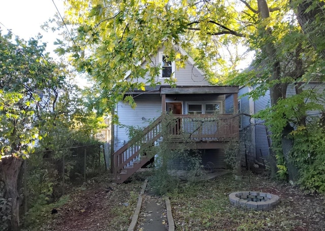 back of house with a fire pit and a deck