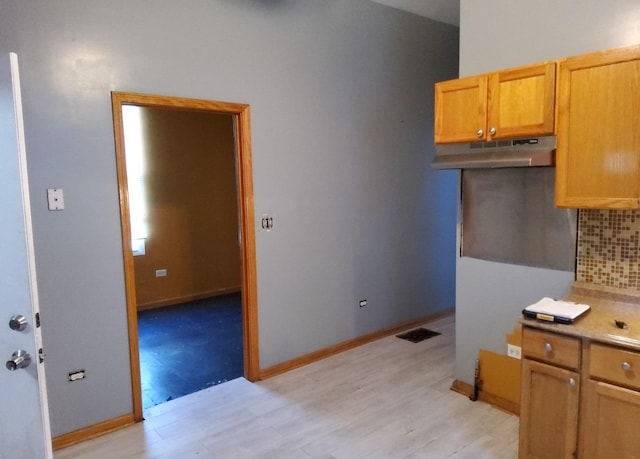 kitchen featuring decorative backsplash and light hardwood / wood-style flooring