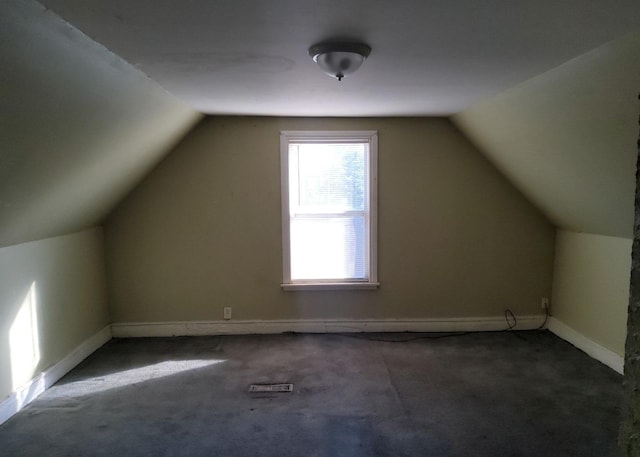 bonus room featuring dark colored carpet and lofted ceiling