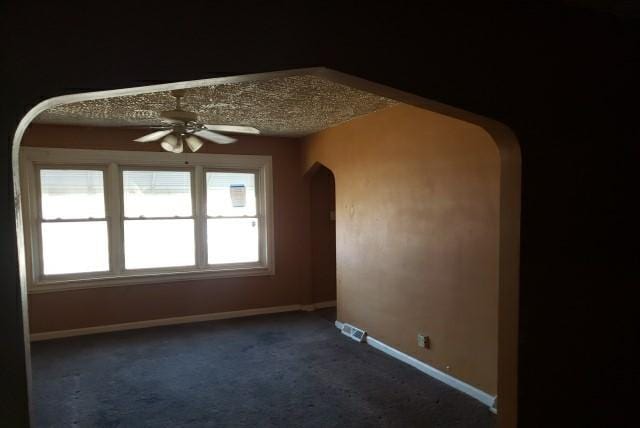 carpeted spare room with ceiling fan