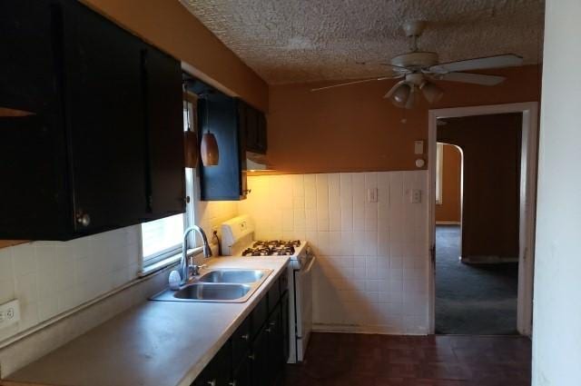 kitchen featuring a textured ceiling, ceiling fan, sink, and white range