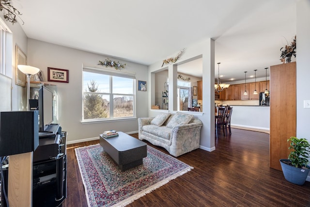 living room with dark hardwood / wood-style flooring and a notable chandelier