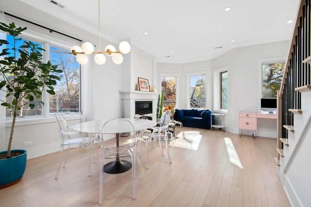 dining space with light wood-type flooring and ornamental molding