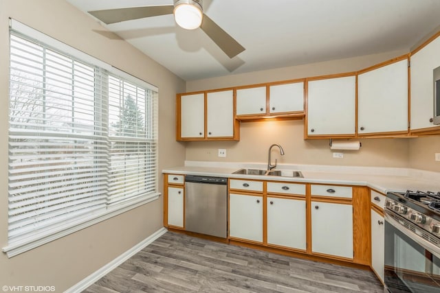 kitchen with ceiling fan, white cabinets, light wood-type flooring, sink, and stainless steel appliances