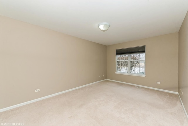 unfurnished room featuring light colored carpet