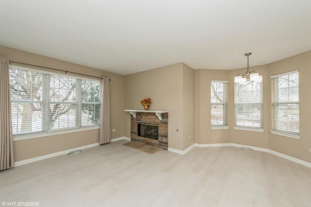 unfurnished living room featuring a fireplace, hardwood / wood-style floors, and an inviting chandelier