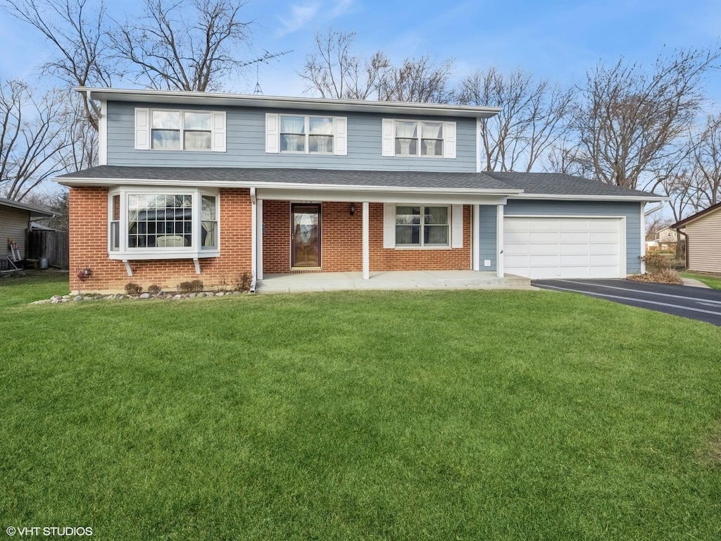 view of front property with covered porch, a garage, and a front lawn