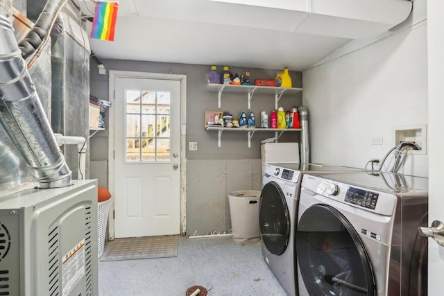 washroom featuring heating unit and washer and clothes dryer