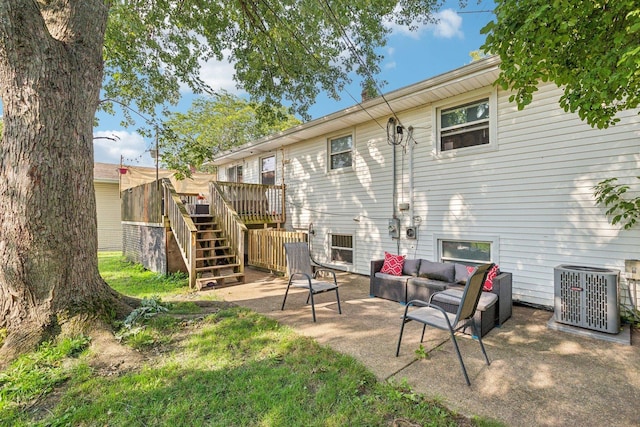 back of property featuring an outdoor living space, a deck, central air condition unit, and a patio area