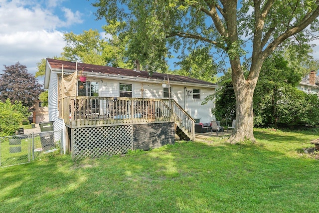 rear view of property featuring a wooden deck and a lawn