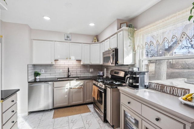 kitchen featuring sink, white cabinets, appliances with stainless steel finishes, and tasteful backsplash