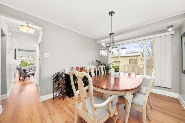 dining space featuring a chandelier, wood-type flooring, and ornamental molding