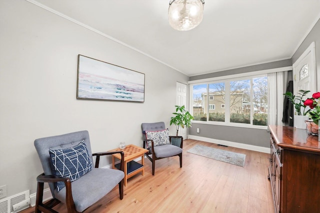 sitting room featuring crown molding and light wood-type flooring