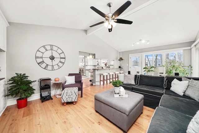 living room featuring vaulted ceiling with beams, light hardwood / wood-style flooring, and ceiling fan