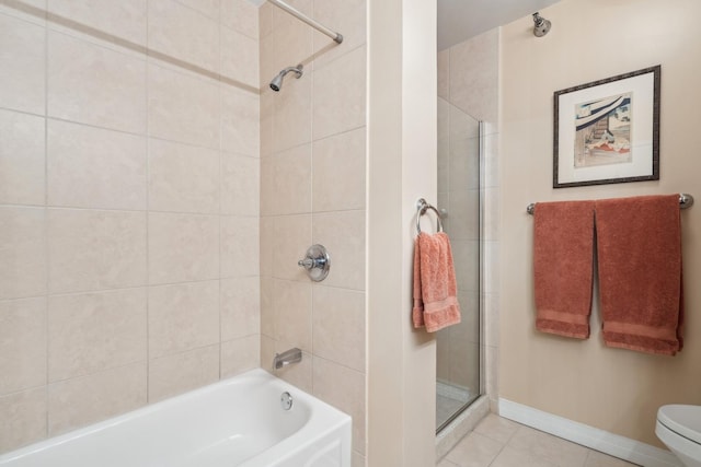 bathroom featuring toilet, tiled shower / bath, and tile patterned floors