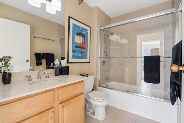 full bathroom with enclosed tub / shower combo, tile patterned floors, toilet, and vanity