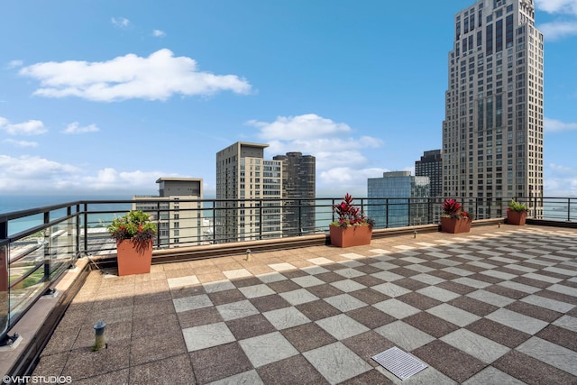 view of patio featuring a water view and a balcony