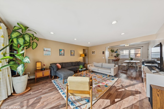 living room with light hardwood / wood-style flooring and a baseboard heating unit