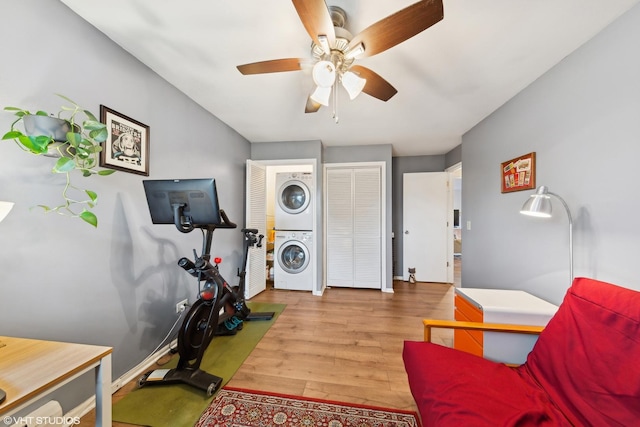 interior space featuring hardwood / wood-style floors, ceiling fan, and stacked washer and clothes dryer