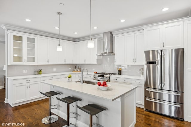 kitchen featuring pendant lighting, white cabinetry, wall chimney range hood, and stainless steel appliances